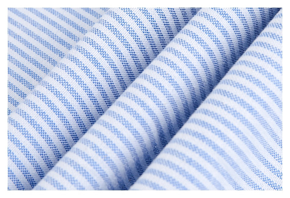 Close-up of white fabric with blue stripes, folded into overlapping ridges to show its texture.