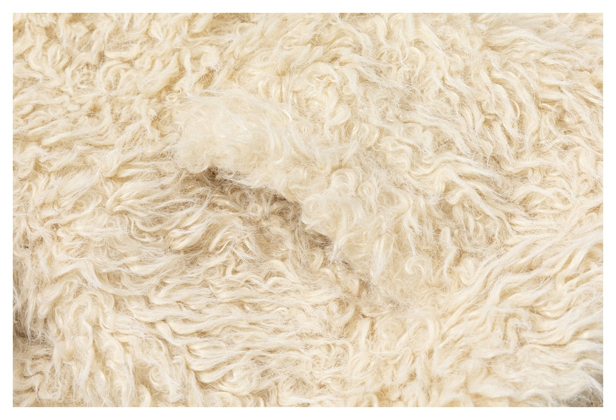 Extreme close-up of the curly, shaggy cream-colored fabric texture.