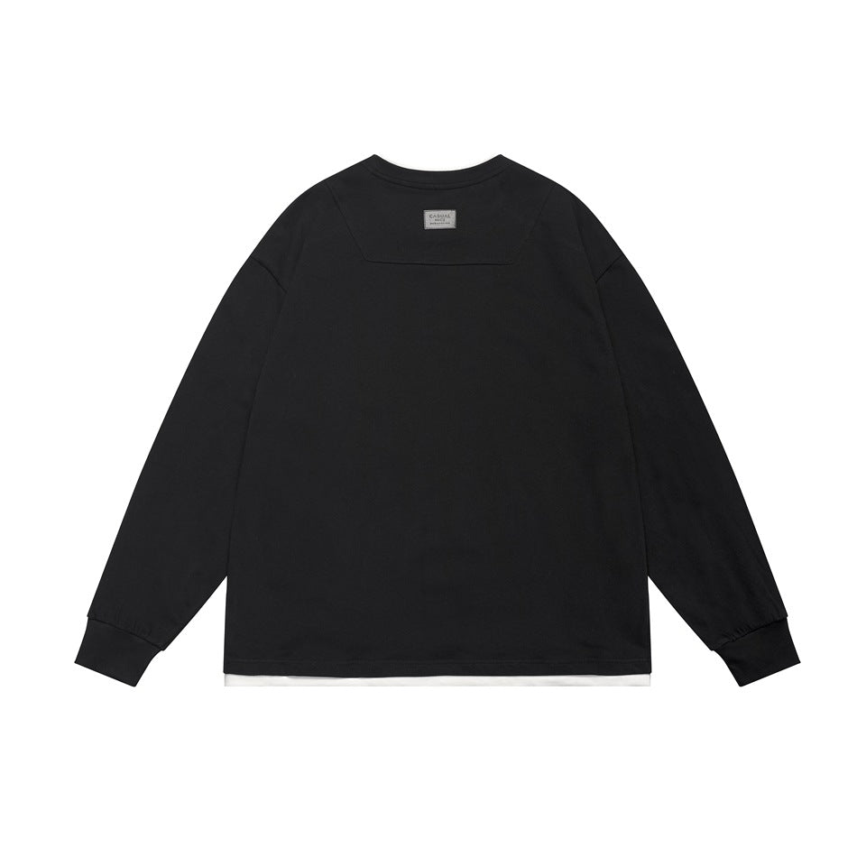 Back view of a black long-sleeve crewneck top with ribbed cuffs and a narrow white layer visible at the hem.