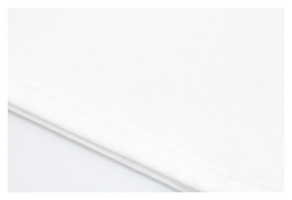 Close-up of a white garment's folded hem and stitching.