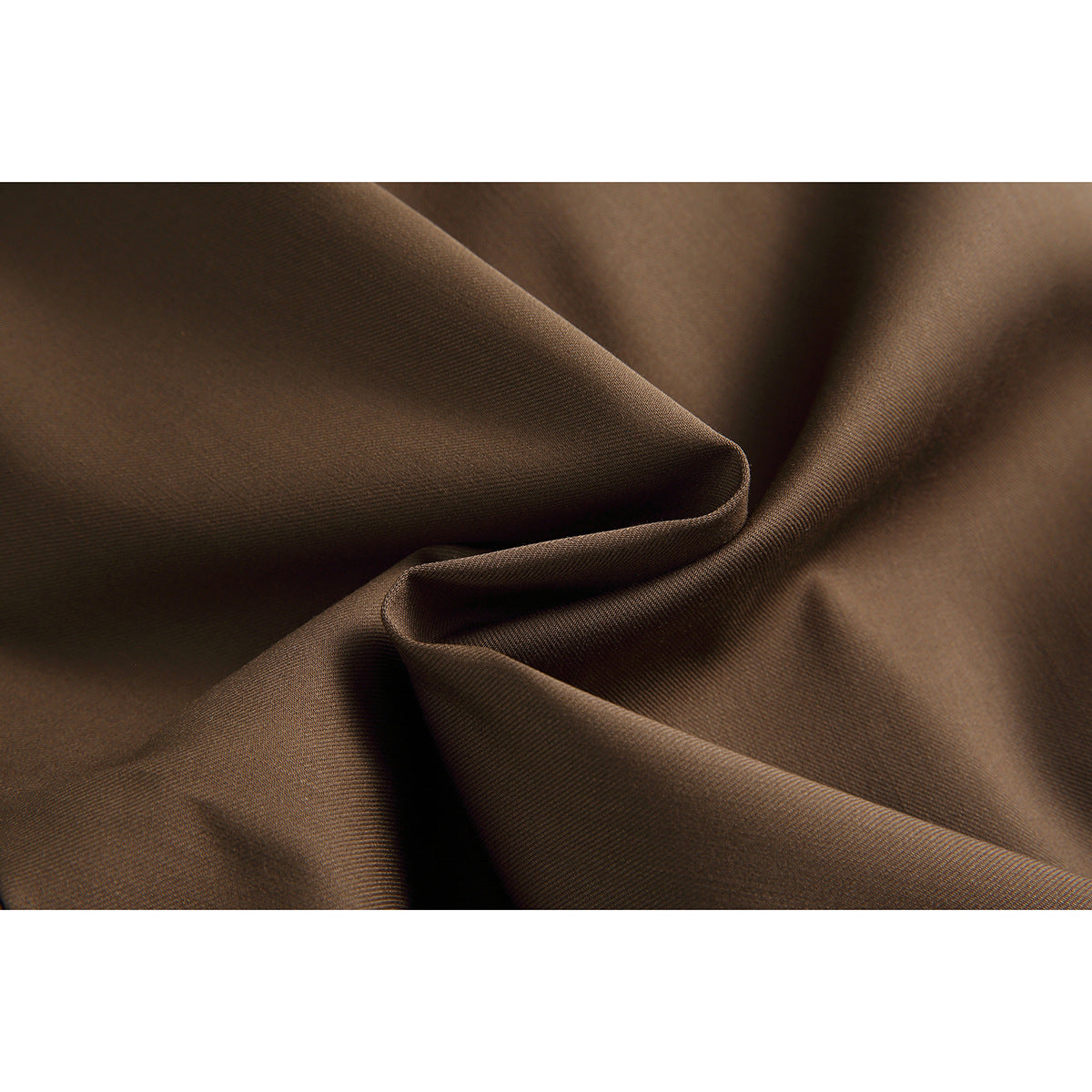 Close-up of brown fabric gathered into folds, showing its surface texture and drape.