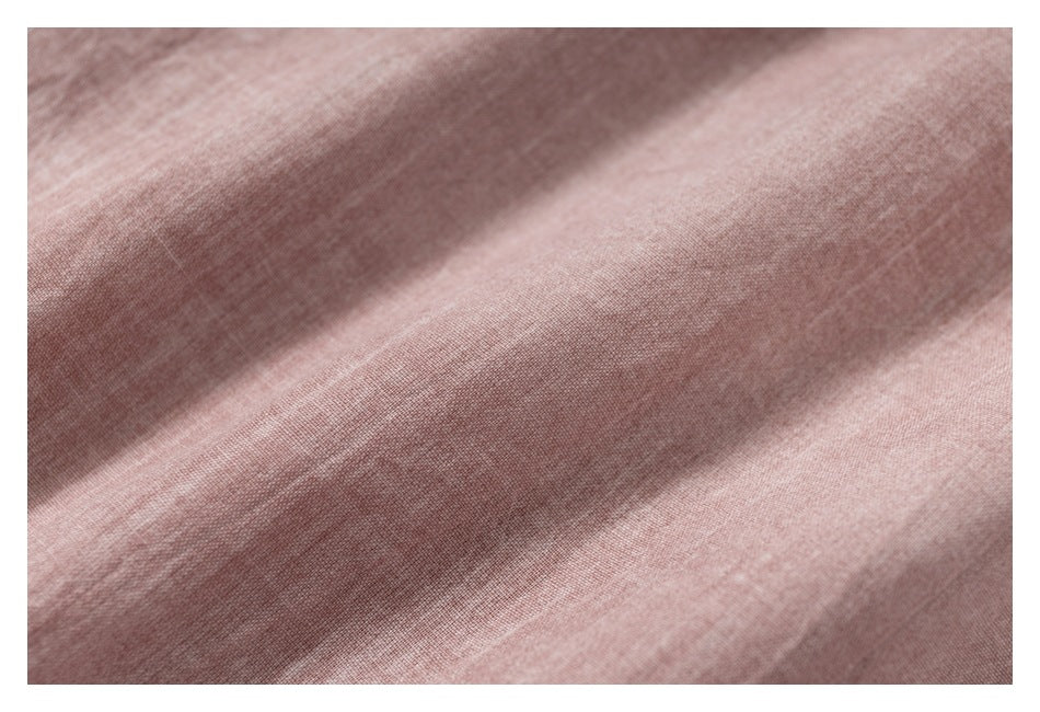 Macro view of the dusty rose garment's softly textured fabric and folds.