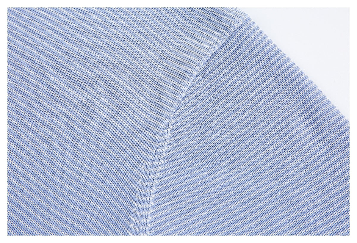 Close-up of the light blue knit sweater's shoulder seam and textured knit.