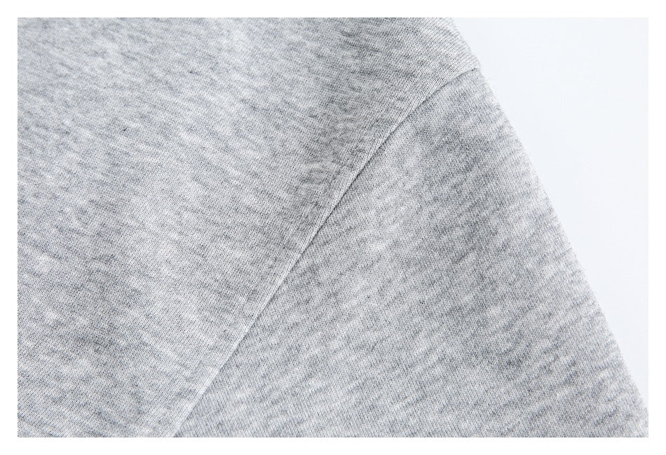 Close-up of a curved seam across heather gray knit fabric.