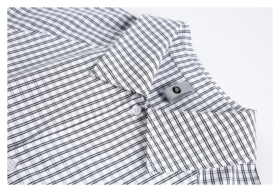 Close-up of a white checked shirt collar, button placket, and small fabric tab.