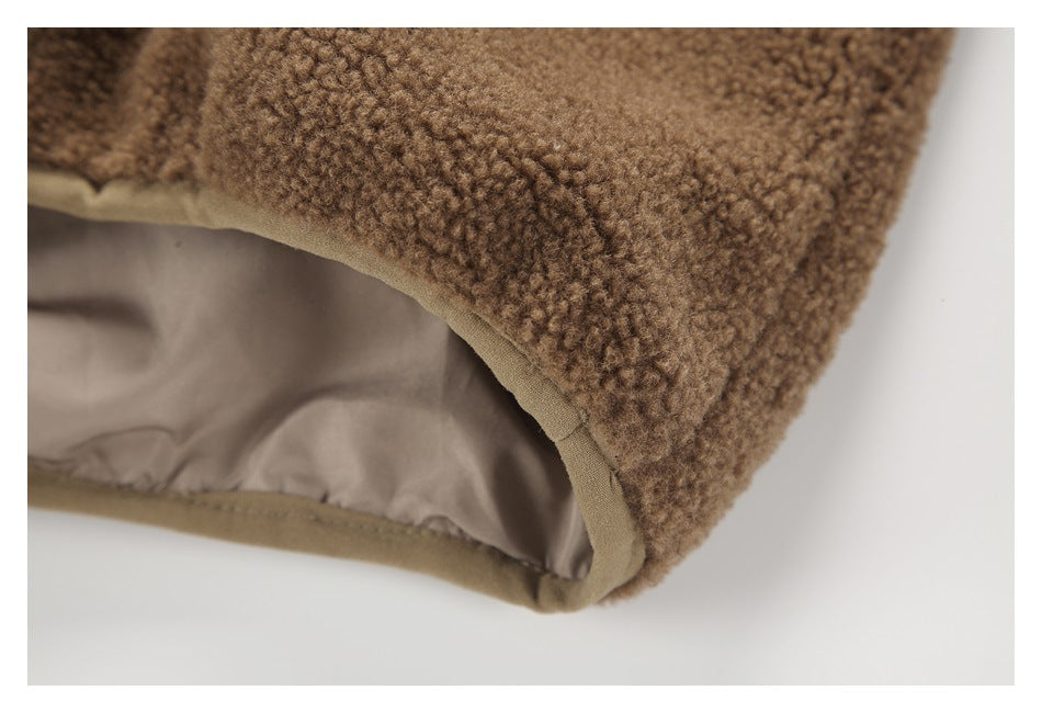 Close-up of a brown fleece edge with beige binding and smooth lining.