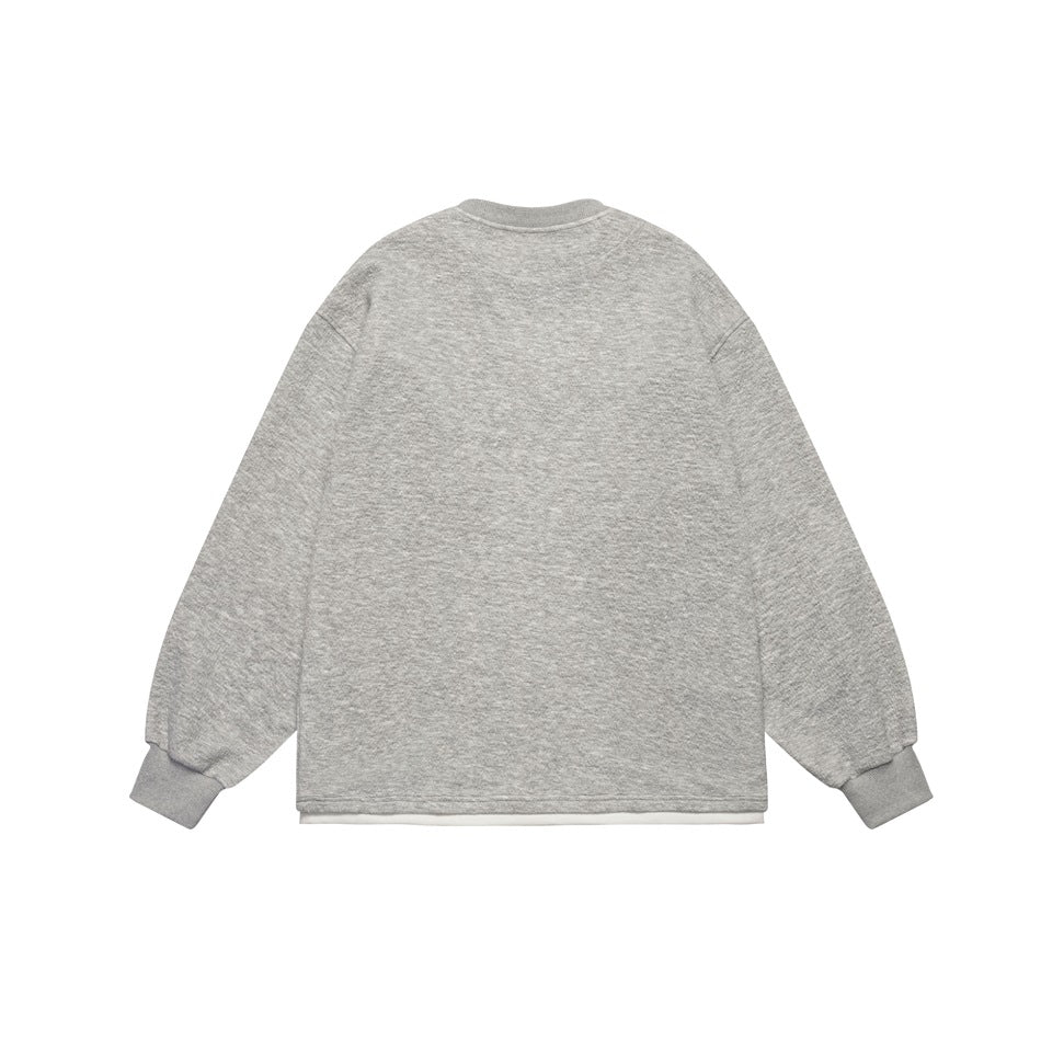 Back view of a light gray long-sleeve sweatshirt with ribbed cuffs and a white layer peeking below the hem.