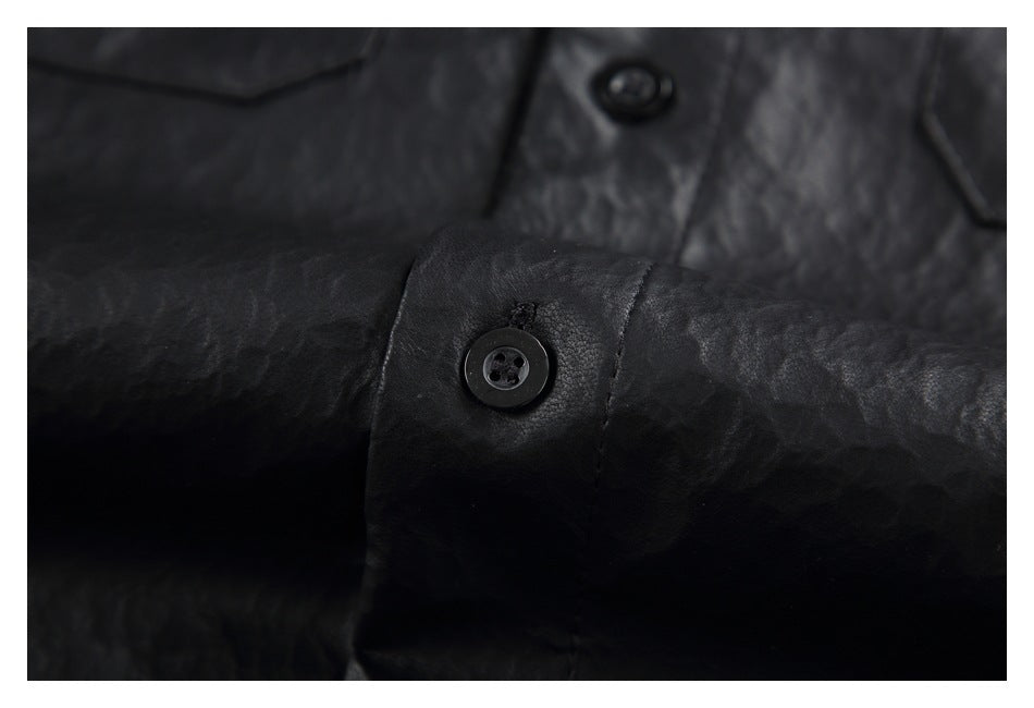 Close-up of a black shirt cuff with a button and stitched buttonhole.