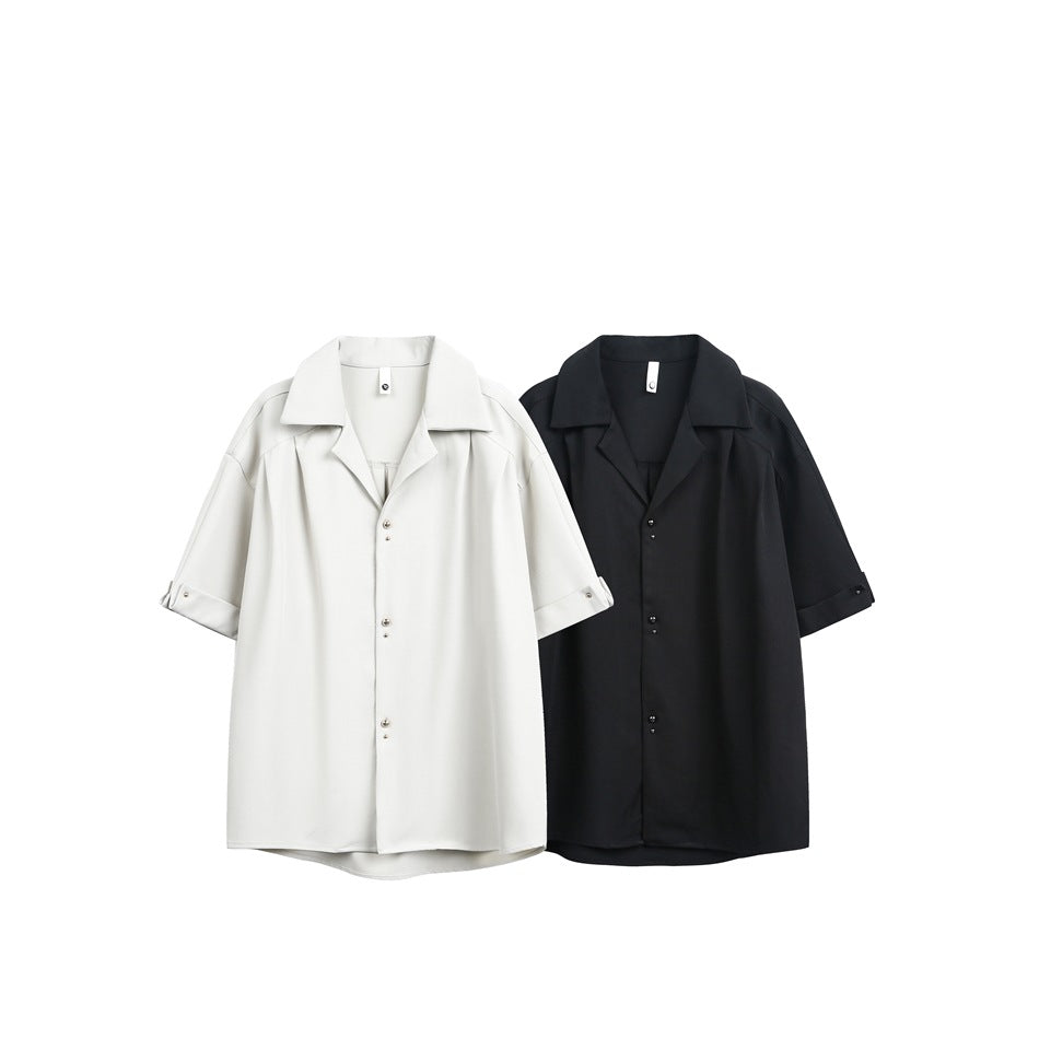 Two short-sleeve button-up shirts shown flat against white: one ivory and one black.