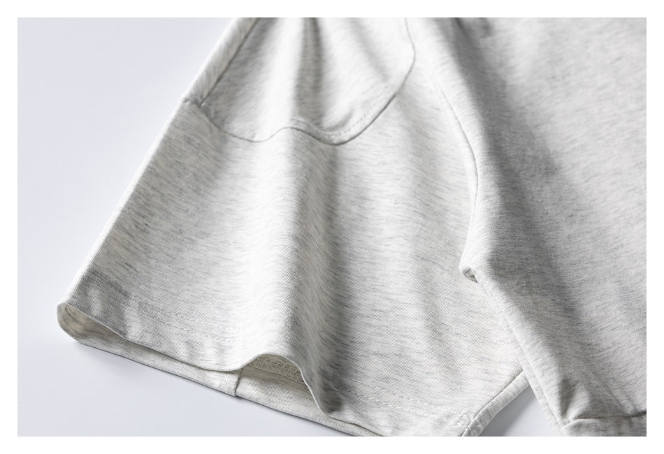 Close-up of a light gray marl shirt sleeve and stitched hem.