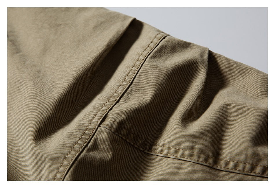 Close-up of tan garment fabric showing a stitched seam and folded panel.