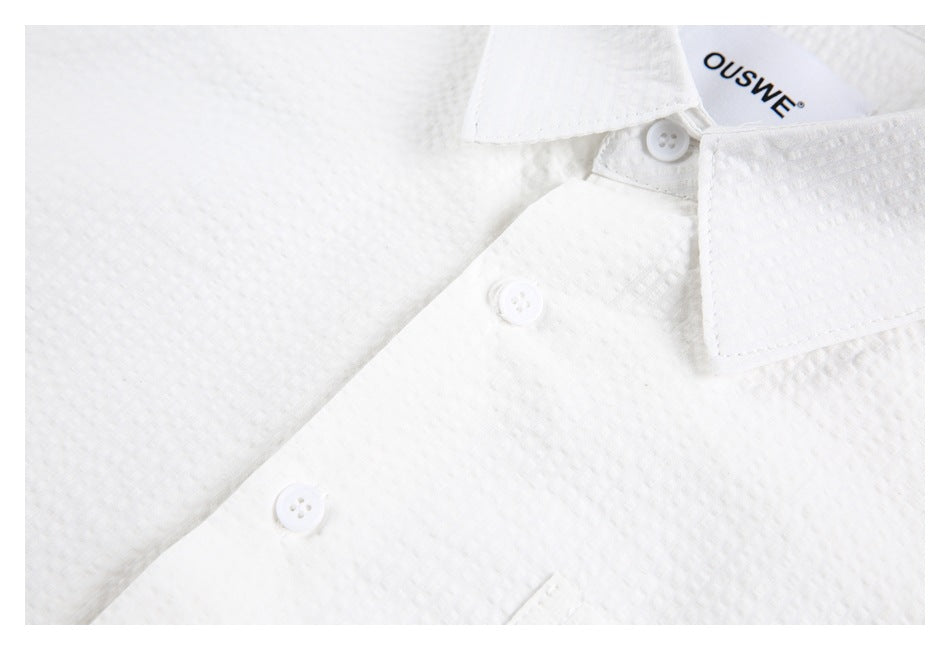Close-up of the white shirt's button front, collar, and textured surface.