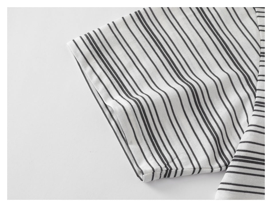 Close-up of a white shirt sleeve with thin black stripes and a folded hem.
