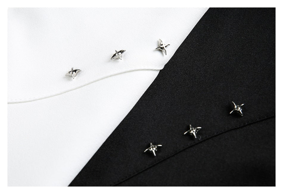Close-up of silver star-shaped hardware on the white and black shirt fabric.