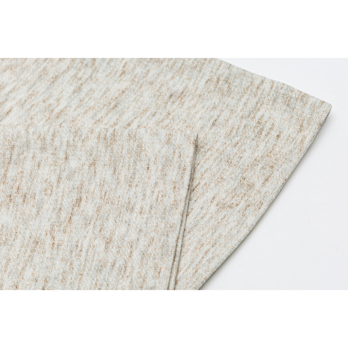 Close-up of a light beige heather garment panel and stitched seam.