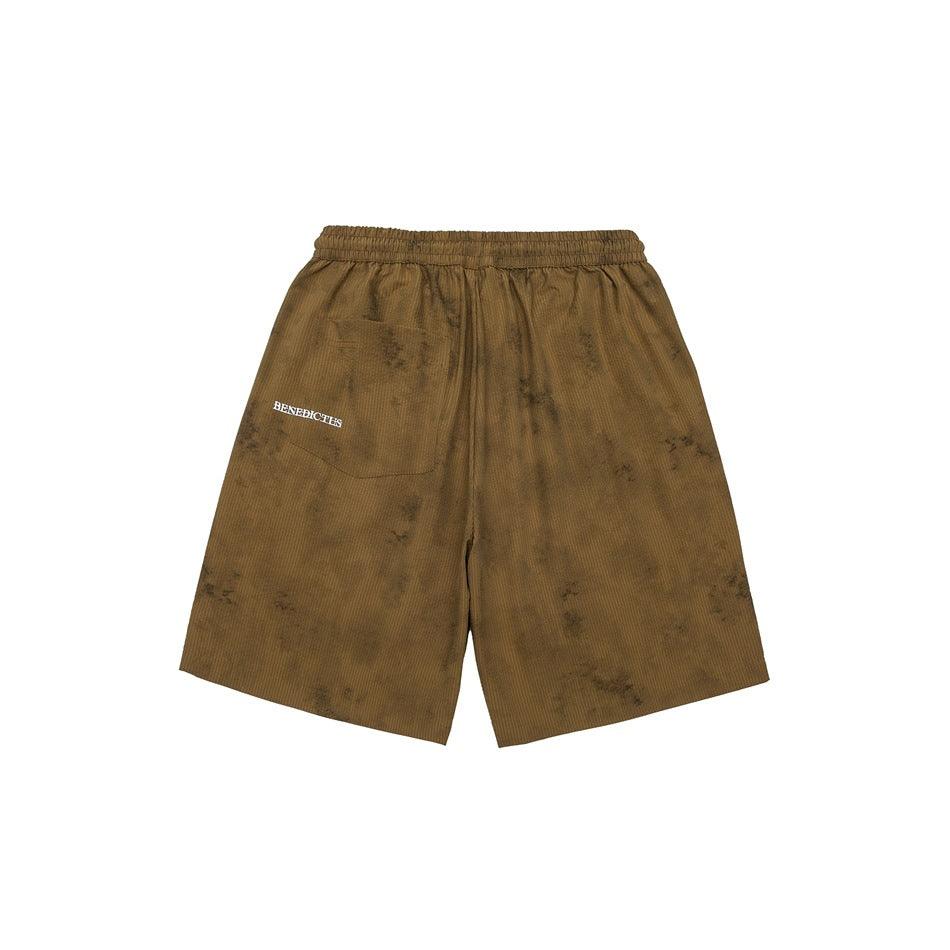 Back view of khaki mottled-wash shorts with elastic waistband, patch pocket and small white printed text