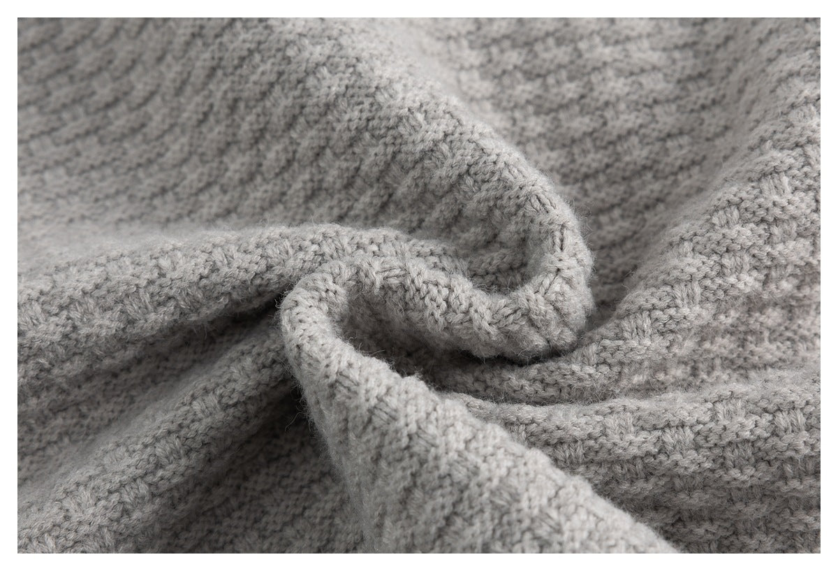 Close-up of the light gray sweater's textured knit fabric gathered into soft folds.