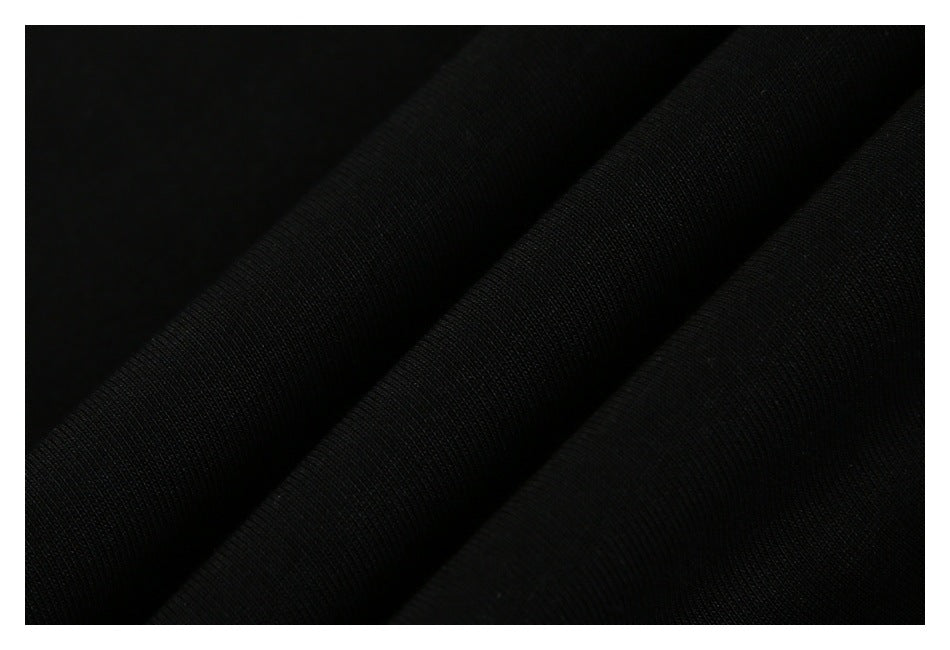 Close-up of black fabric arranged in soft folds, showing its surface texture.