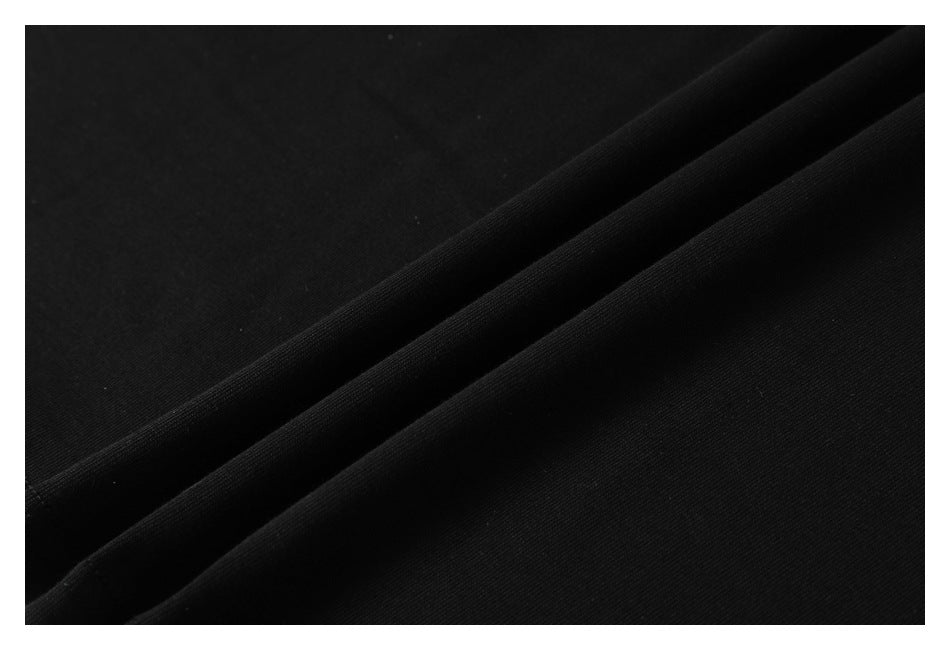 Close-up of black fabric arranged in folds, showing its surface texture.