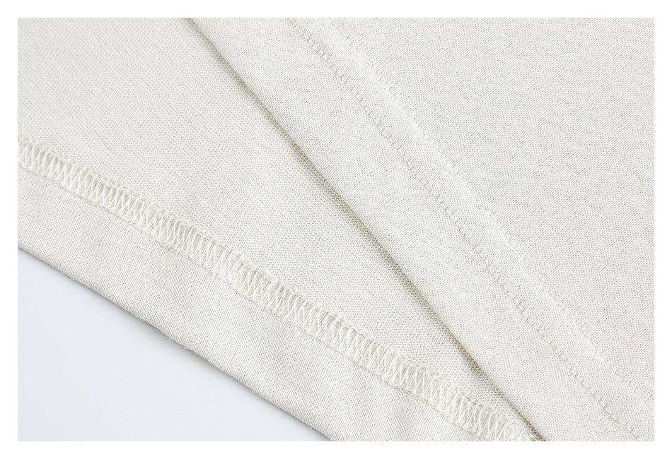 Close-up of off-white garment seams and overlocked stitching.