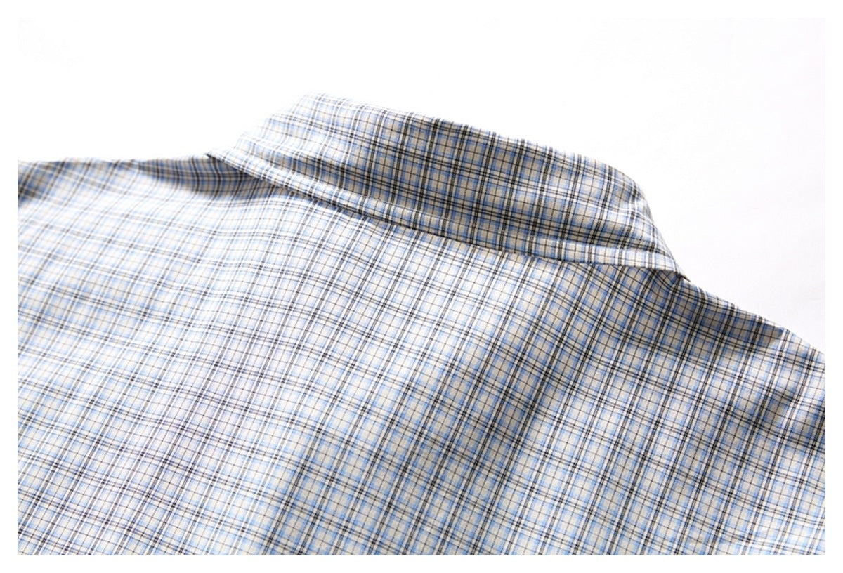 Close-up of the collar and upper back of a white shirt with a blue and gray plaid pattern.