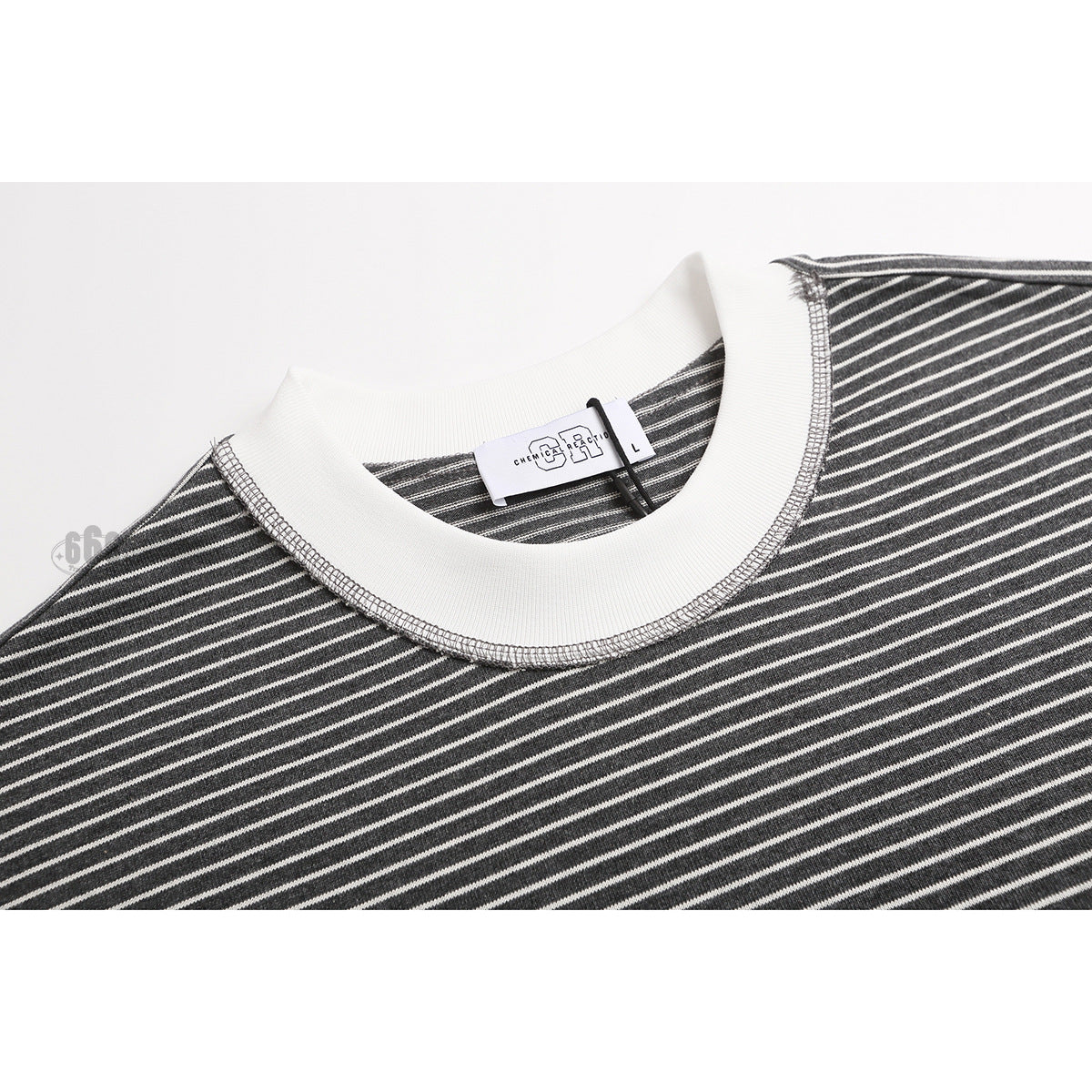 Close-up of a charcoal-and-white striped T-shirt's white ribbed crew neck and inner label.