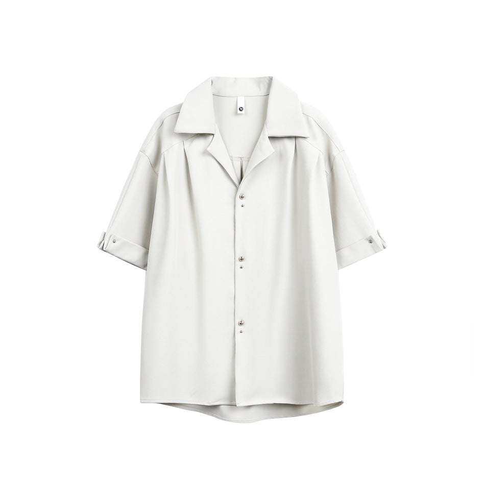 Light gray-white short-sleeve shirt flat lay with notched collar, stud buttons and studded cuffs