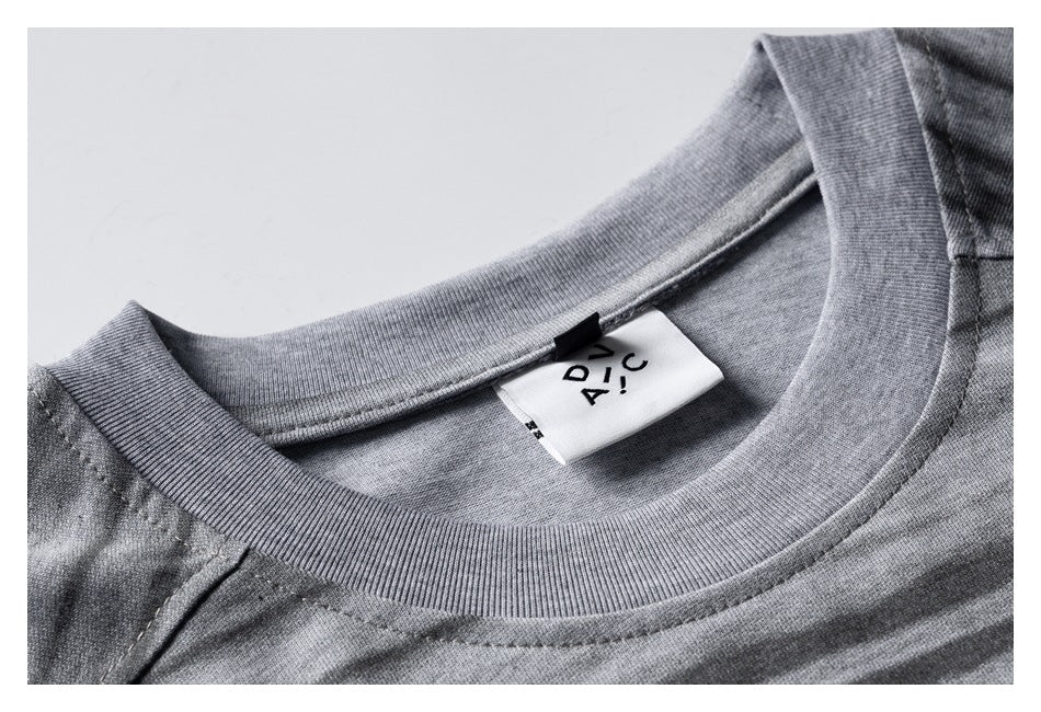 Close-up of a gray striped T-shirt neckline and ribbed collar, with a white sewn-in label.