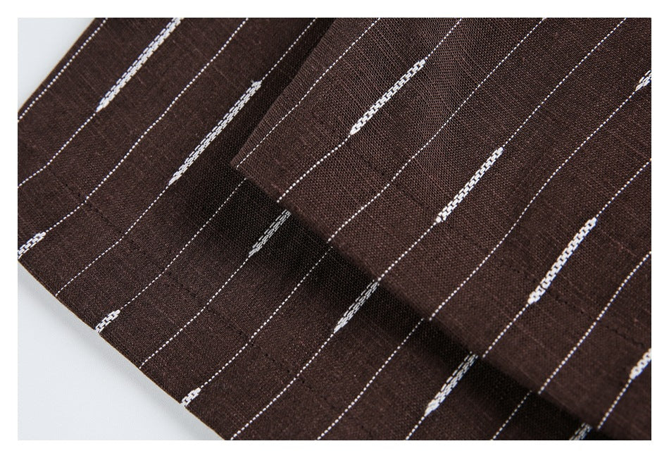Close-up showing folds and woven texture of brown fabric with thin white dashed stripes.