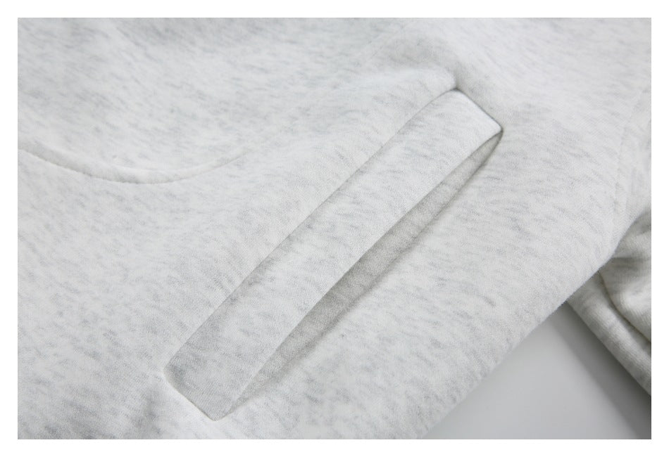 Close-up of a long welt pocket on the light gray marled jacket.