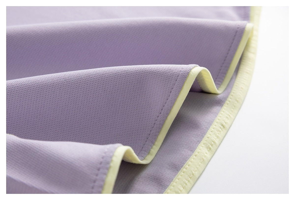 Close-up of lavender fabric edges finished with pale yellow trim and stitching.