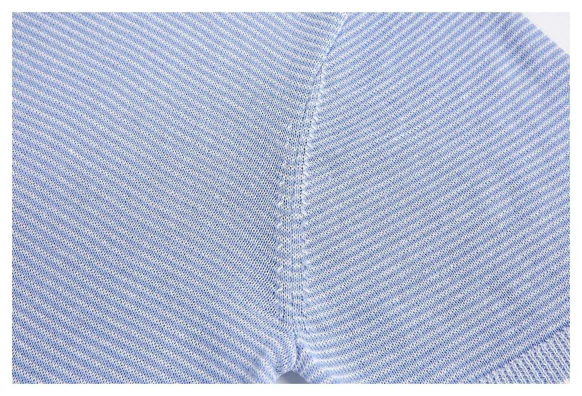 Close-up of a seam joining panels of light blue speckled knit fabric.
