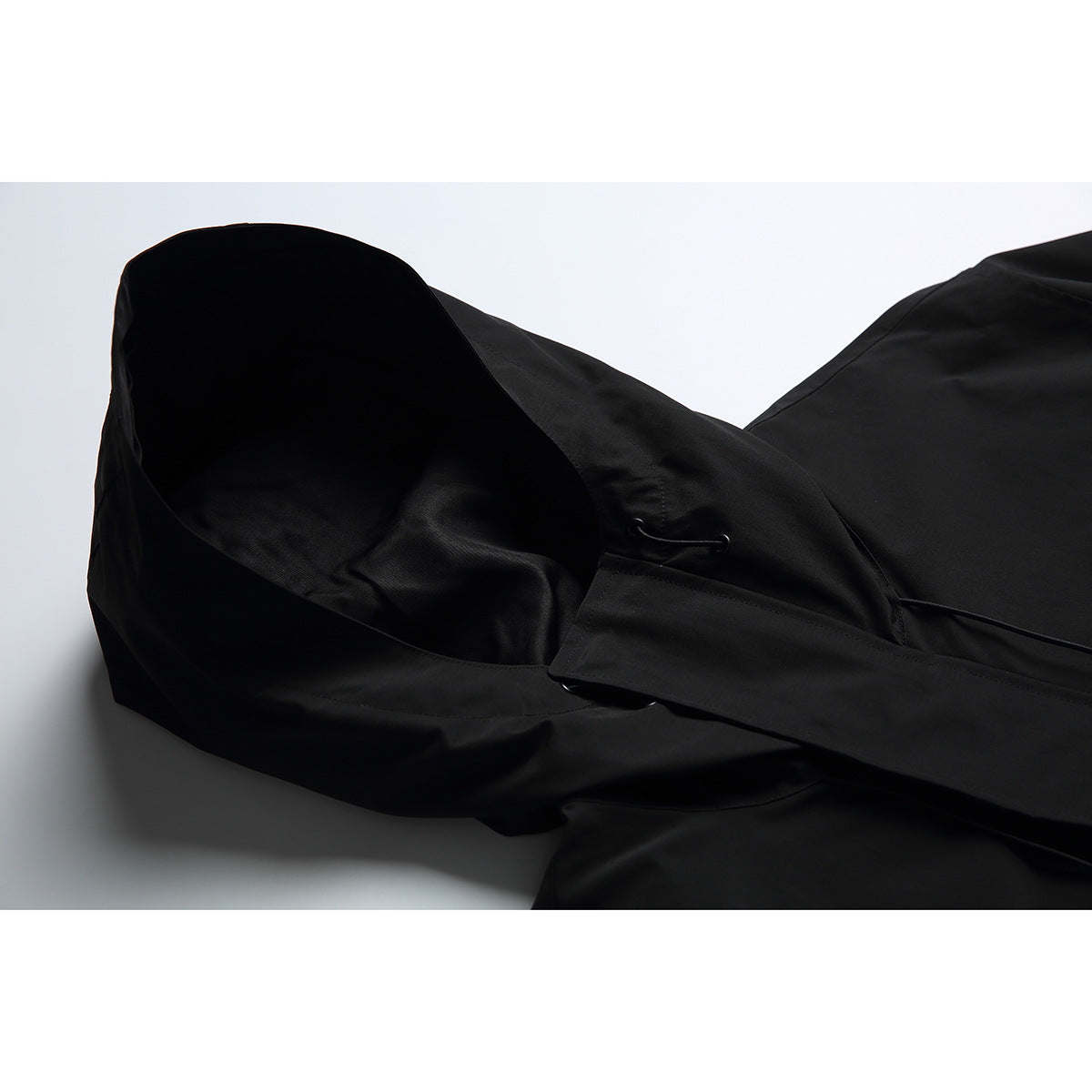 Close-up of a black jacket hood and its drawcord eyelet.
