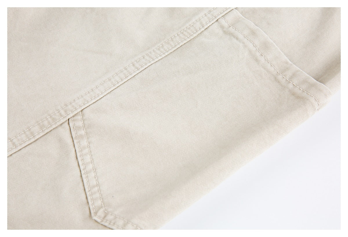 Close-up of a stitched pocket corner on light beige pants.