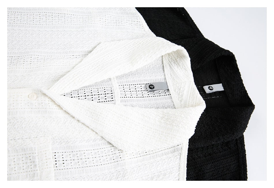 Close-up of the collars and inner labels of white and black textured tunics.