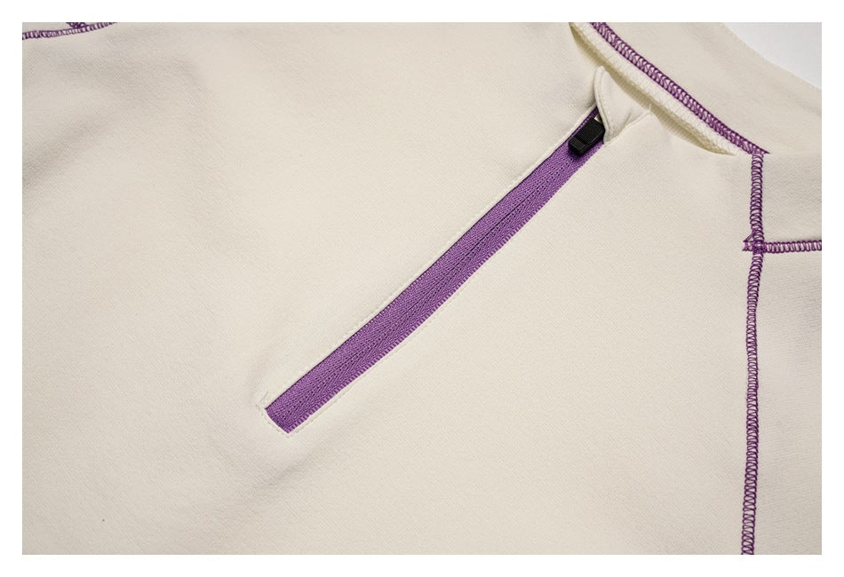 Close-up of a purple zipper and contrast stitching on the ivory top.