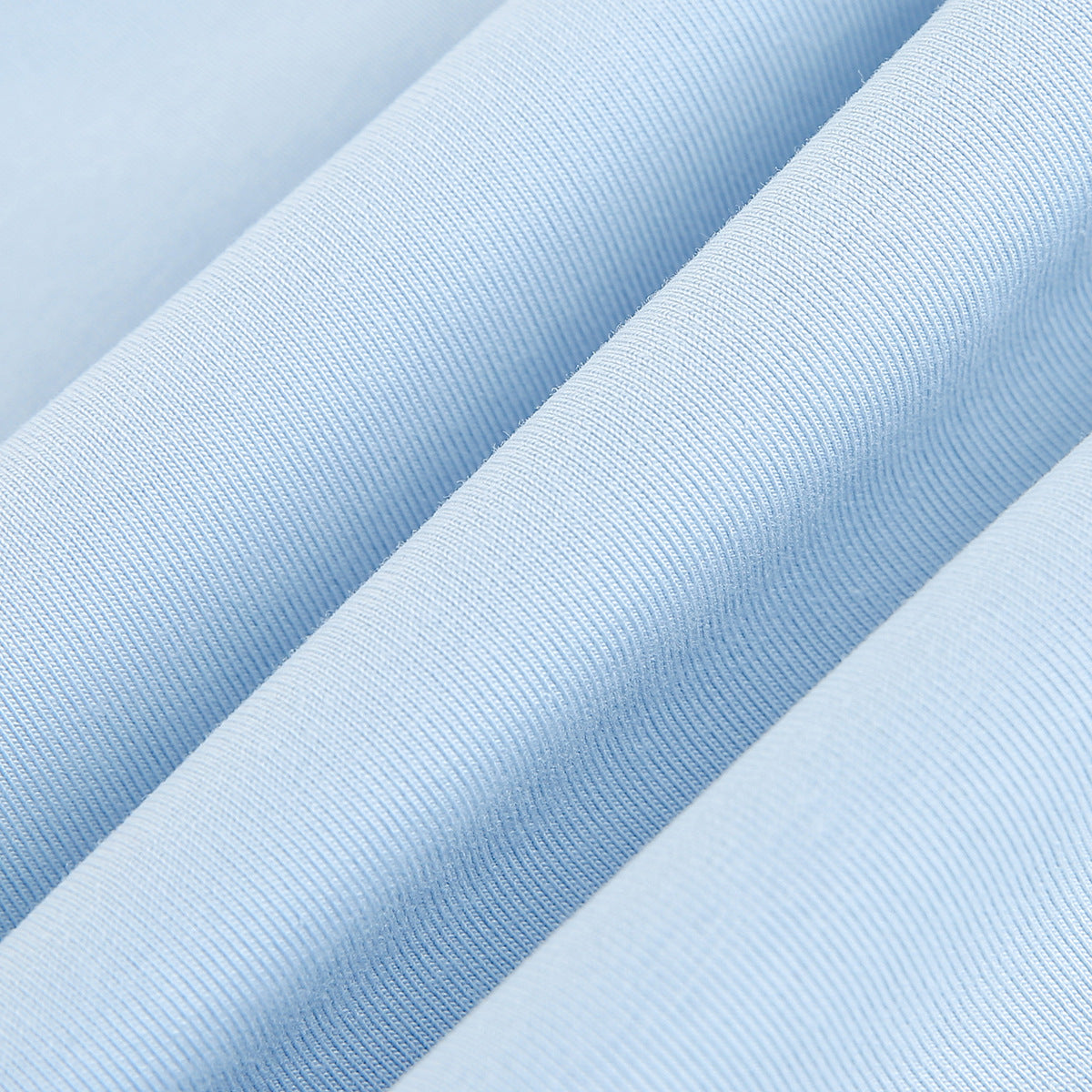 Macro view of pale blue fabric gathered into folds, showing its fine ribbed texture.