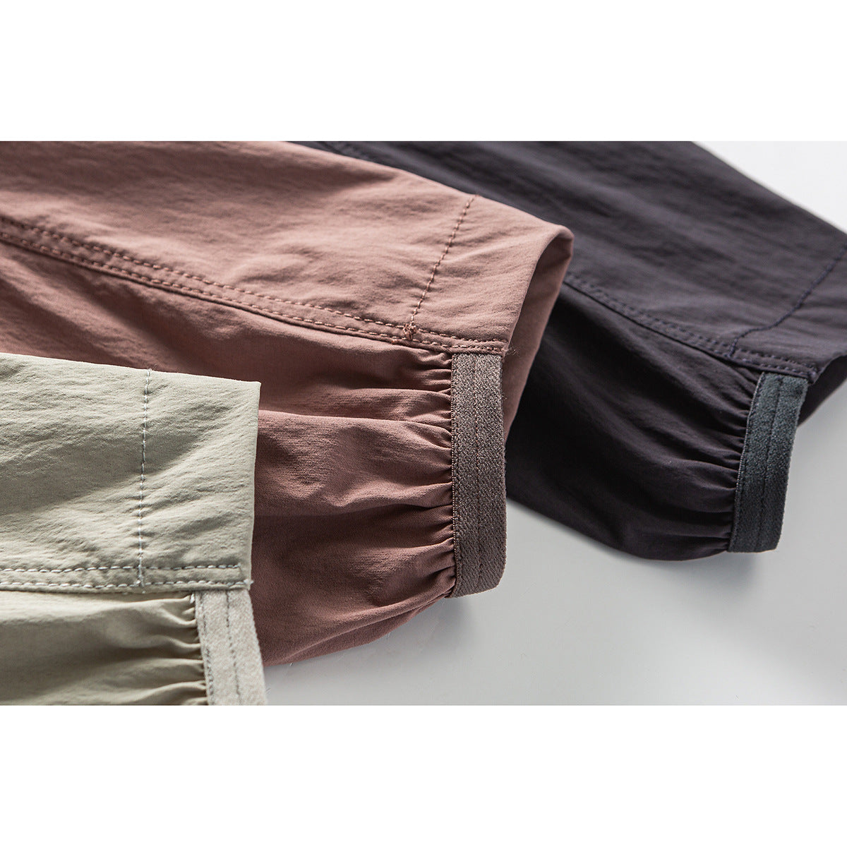 Close-up of gathered sleeve cuffs with hook-and-loop tabs on ivory, dusty rose, and charcoal jackets.