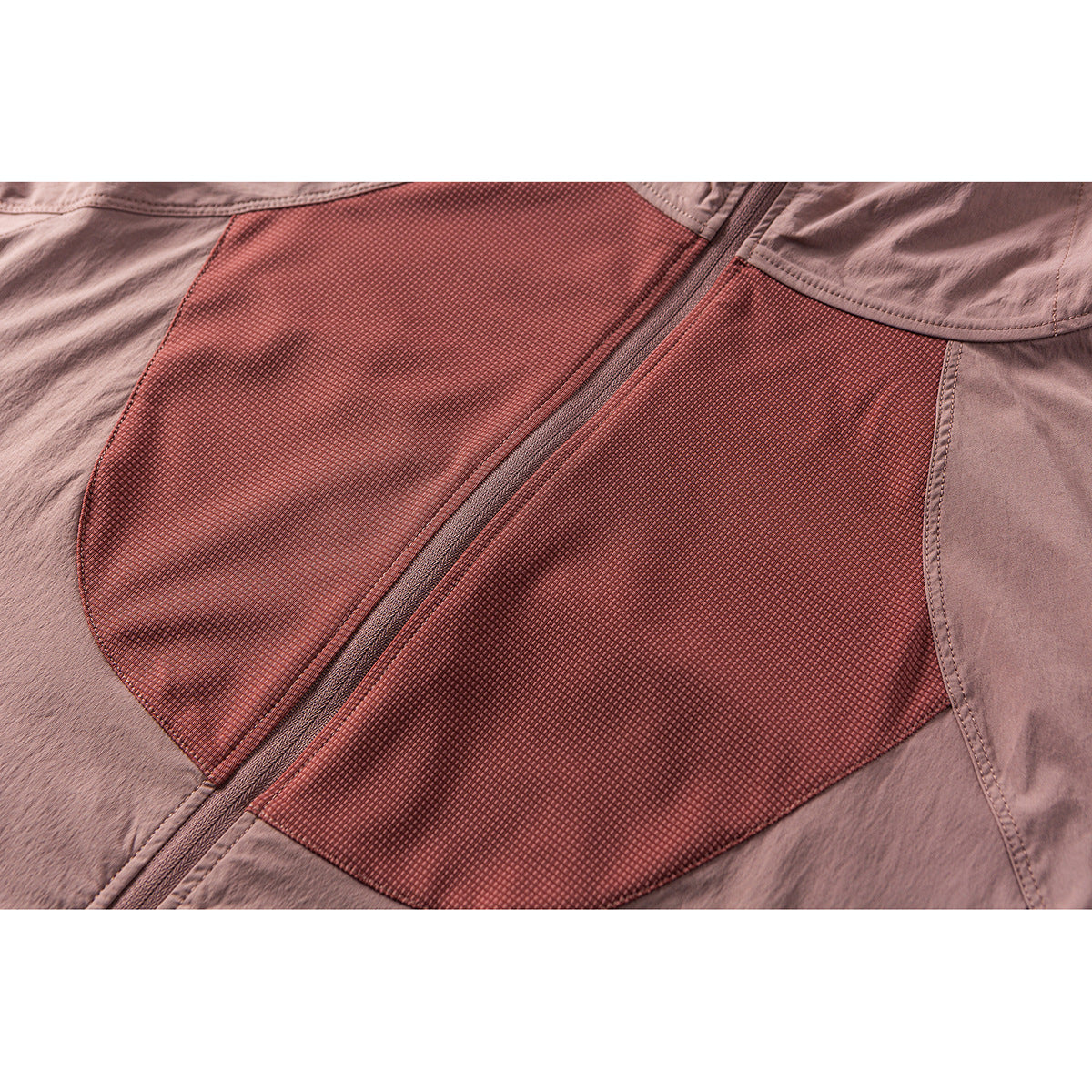Close-up of the dusty rose jacket's front zipper and contrasting textured reddish panels.