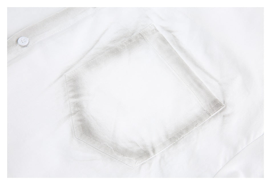 Close-up of a white shirt's stitched chest pocket and part of the button placket.