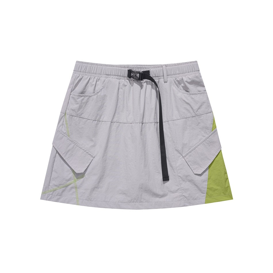 Gray mini cargo skirt with elastic waist, black buckle strap, flap pockets and green side panel