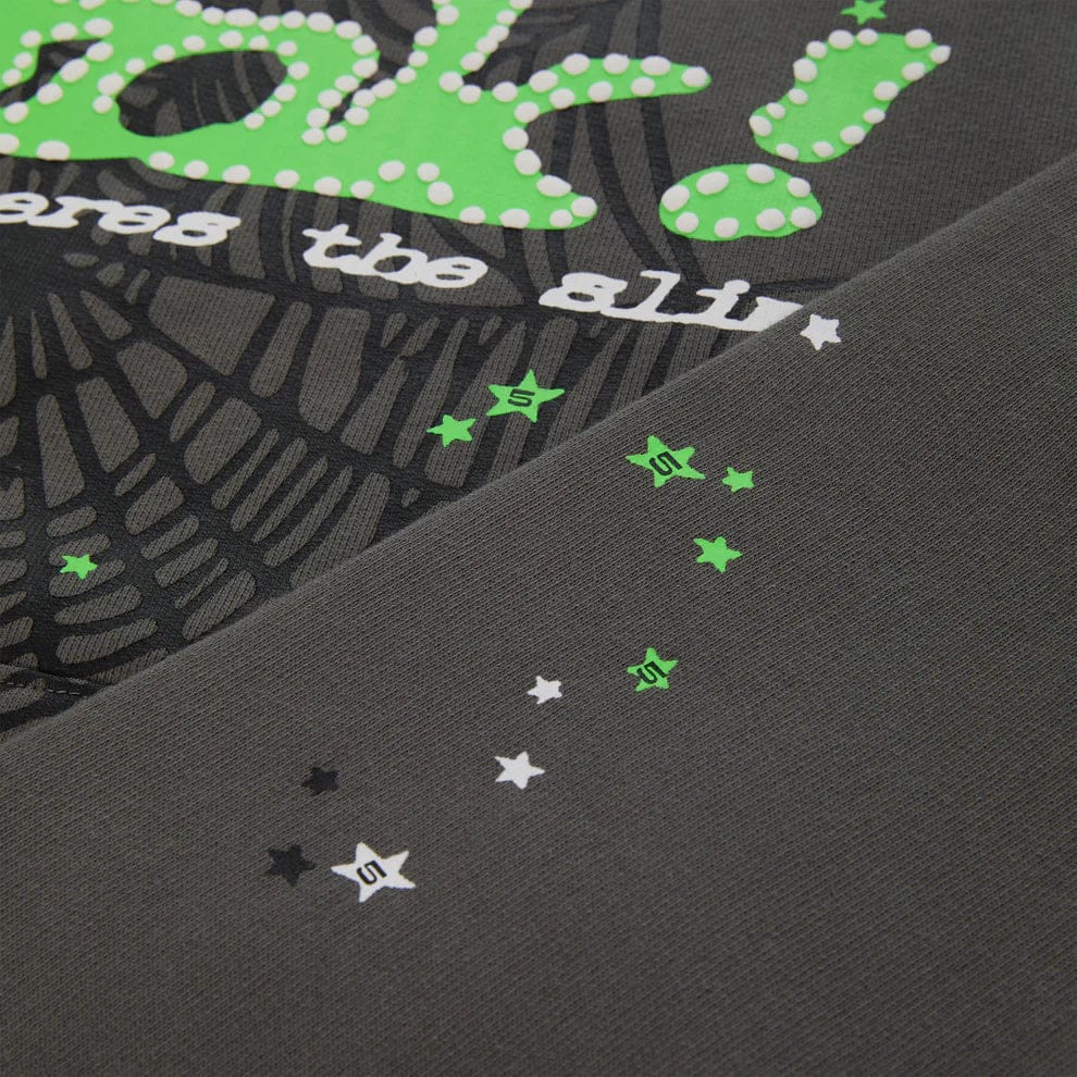 Close-up of fabric from the Sp5der “P!nk! Hares the Slime” Olive Green Hoodie, featuring a spiderweb pattern and white, green, and black details—perfect for standout streetwear in this 440GSM heavyweight pullover.