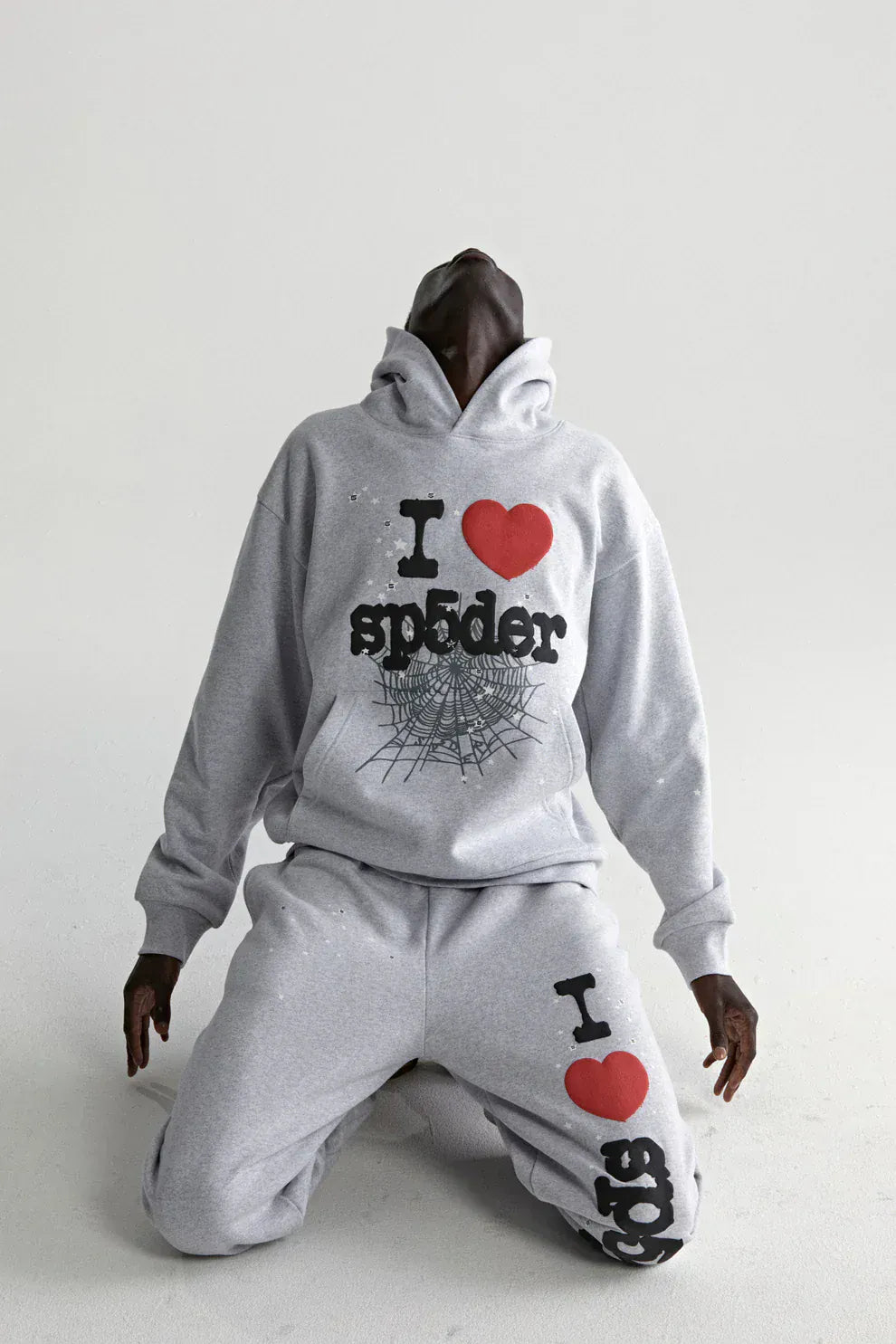 Wearing the Sp5der “I Love Sp5der” Hoodie in grey, a 440GSM heavyweight oversized streetwear pullover, this Y2K-inspired look features bold text and web graphics—perfect for standout style.
