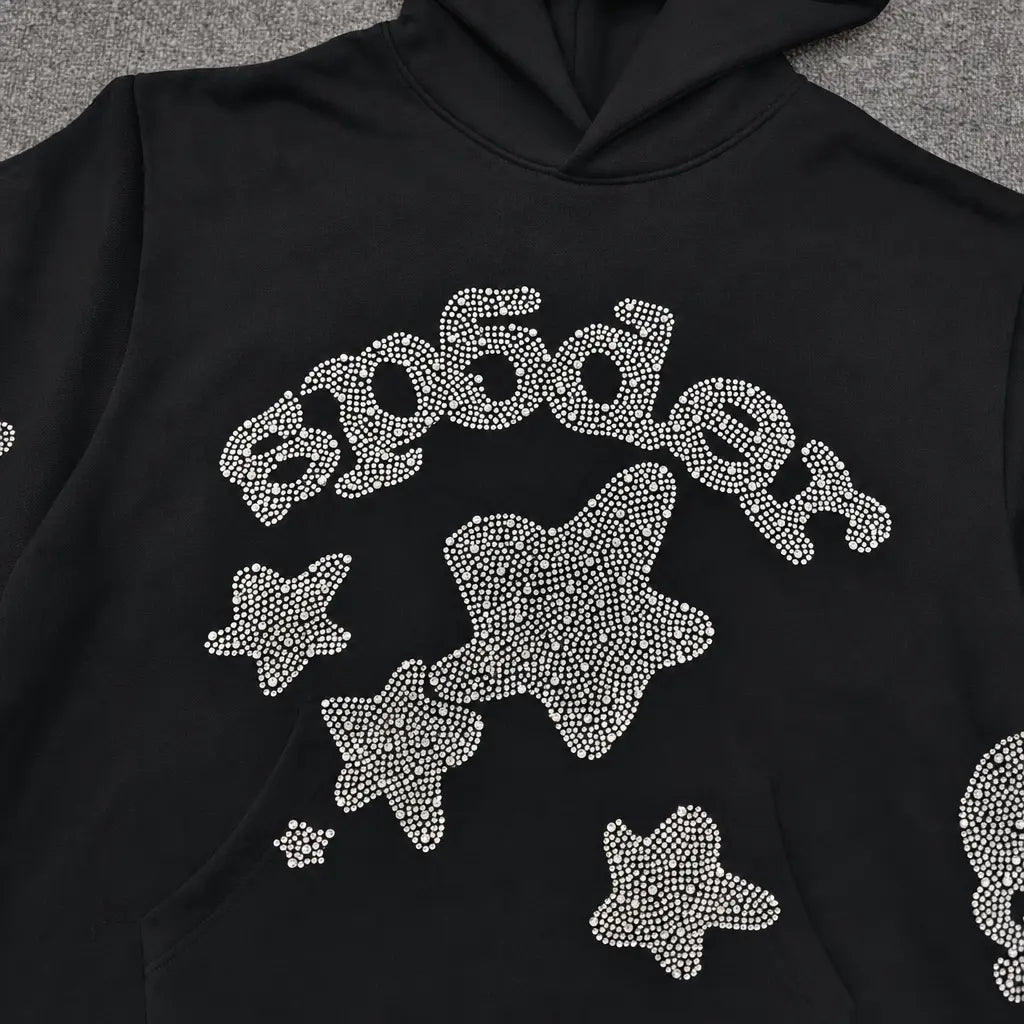 The Sp5der Black Rhinestone Star Logo Hoodie is made from 100% cotton and features "Sp5der" and star designs on the front in white rhinestones―ideal for streetwear style.