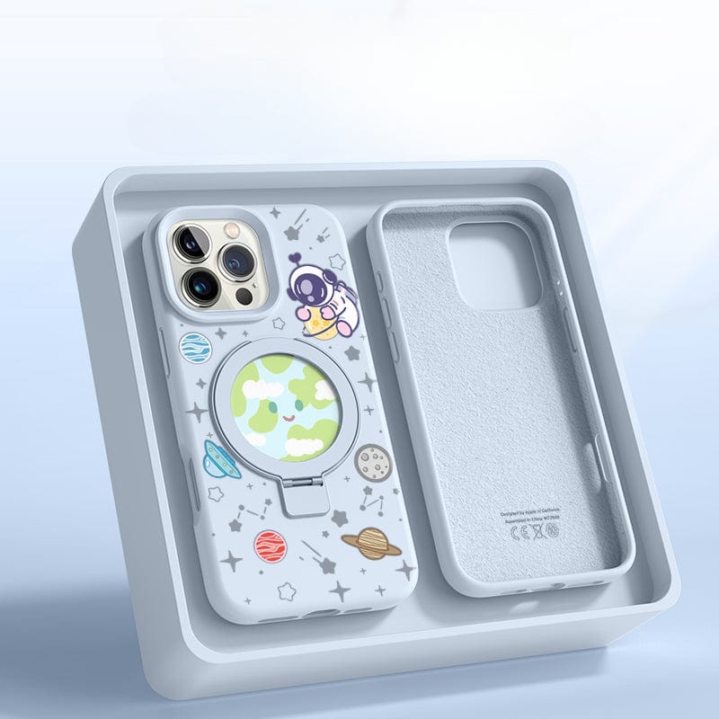 An iPhone 16 Pro Max in a Pink Silicone MagSafe Case with Stand, featuring a space theme complete with planets and stars, rests in an open beige box with an additional slot for another phone or accessory.