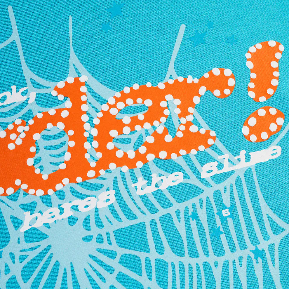 Close-up of bold orange and white "der! here’s the gi-" text over a blue, web-patterned background with a number 5, evoking the streetwise flair of the Sp5der “Nevermind the Spider” Sky Blue 440GSM Heavyweight Streetwear Hoodie.