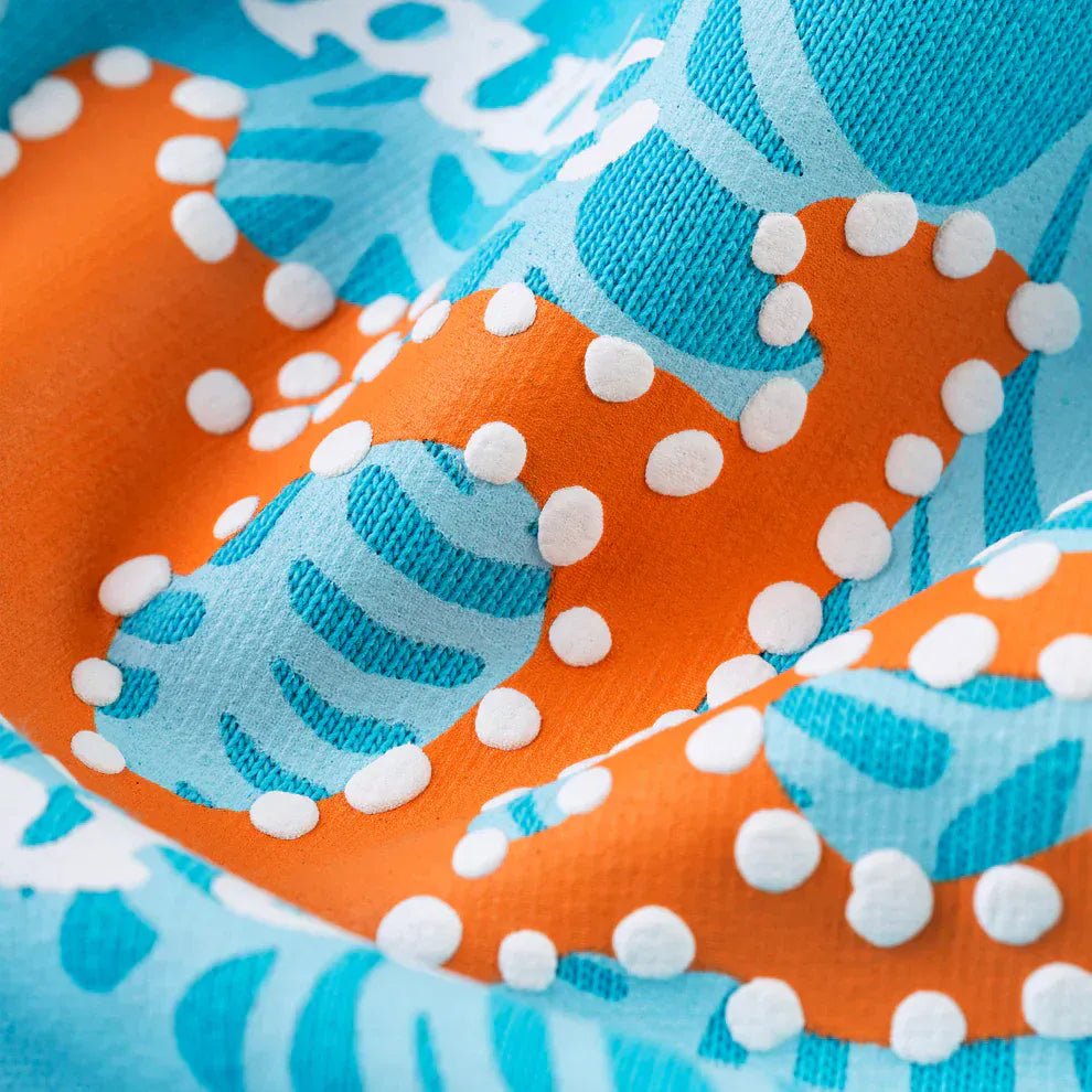 Close-up of sky blue and orange abstract fabric with white raised dots—crafted from premium cotton fleece, as seen in the Sp5der “Nevermind the Spider” Hoodie, a 440GSM heavyweight streetwear pullover.