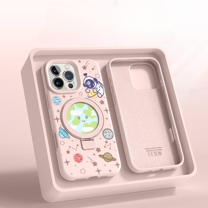 An iPhone 16 Pro Max in a Pink Silicone MagSafe Case with Stand, featuring a space theme complete with planets and stars, rests in an open beige box with an additional slot for another phone or accessory.
