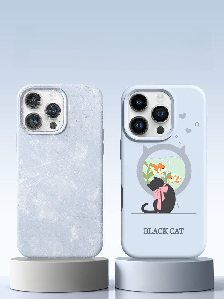 Two smartphones are displayed on round stands. The phone on the left has a textured, frosted case with shockproof protection, while the phone on the right features a light blue iPhone 16 Pro Max Black Cat Case – a liquid silicone, shockproof, slim fit protective cover adorned with a charming illustration of a black cat and fish bowl.