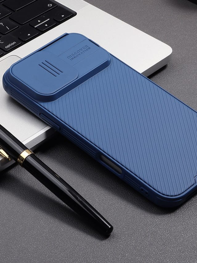 An iPhone 16 Pro Max encased in a textured, anti-scratch Camera Slider case rests on a silver laptop keyboard. A black pen is positioned next to the smartphone.